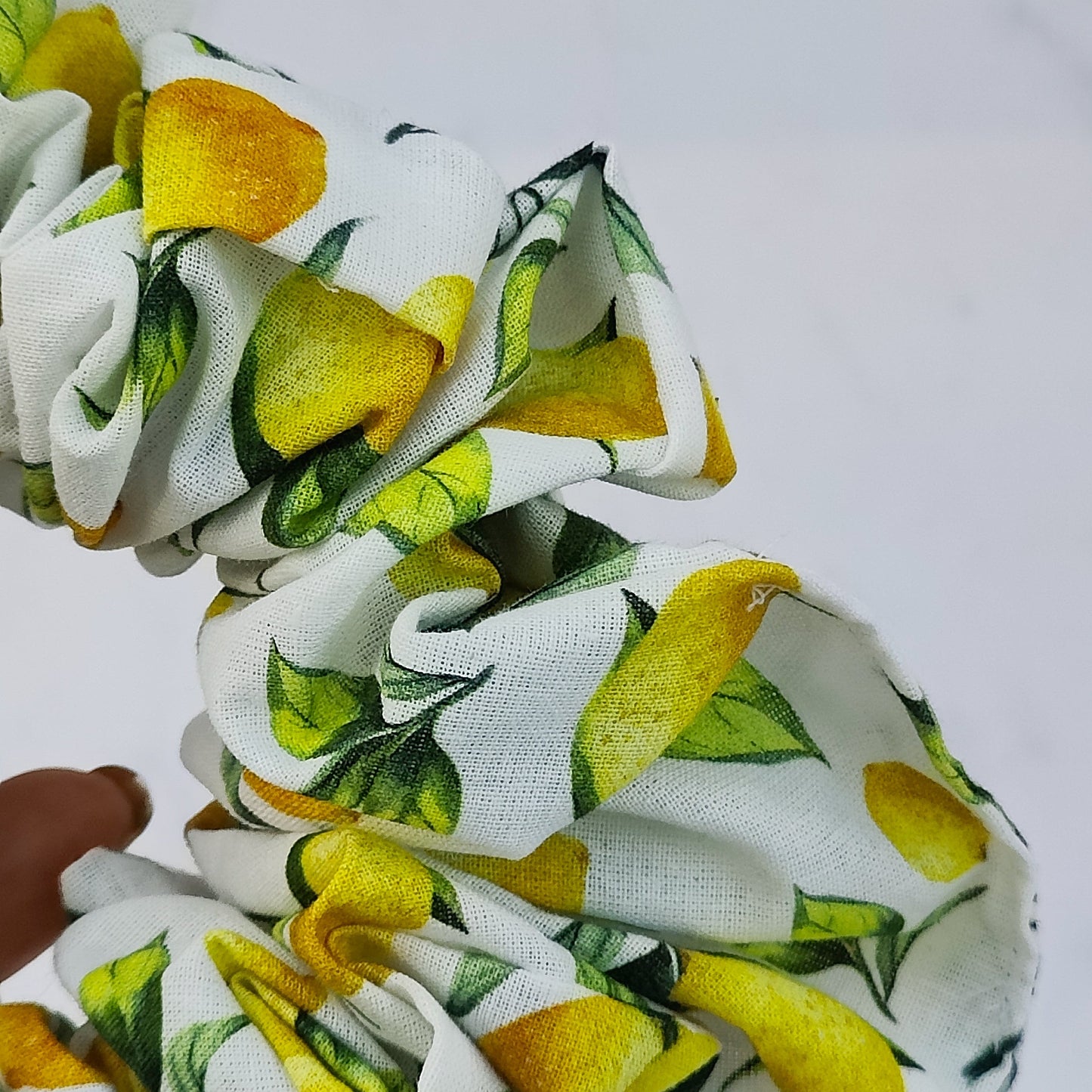 Handmade lemon print scrunchie with yellow lemons on white fabric hair tie