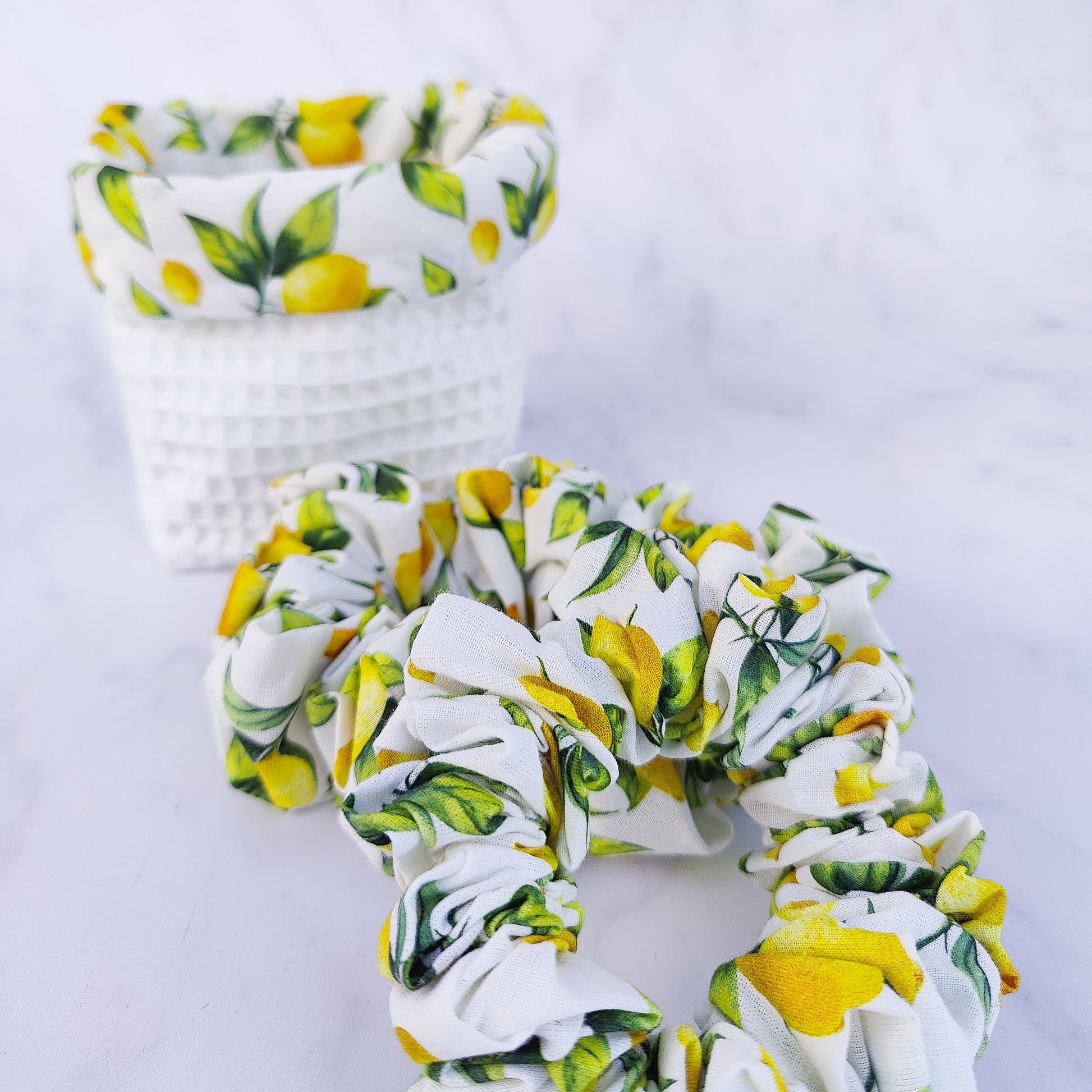 Handmade lemon print scrunchie with yellow lemons on white fabric hair tie