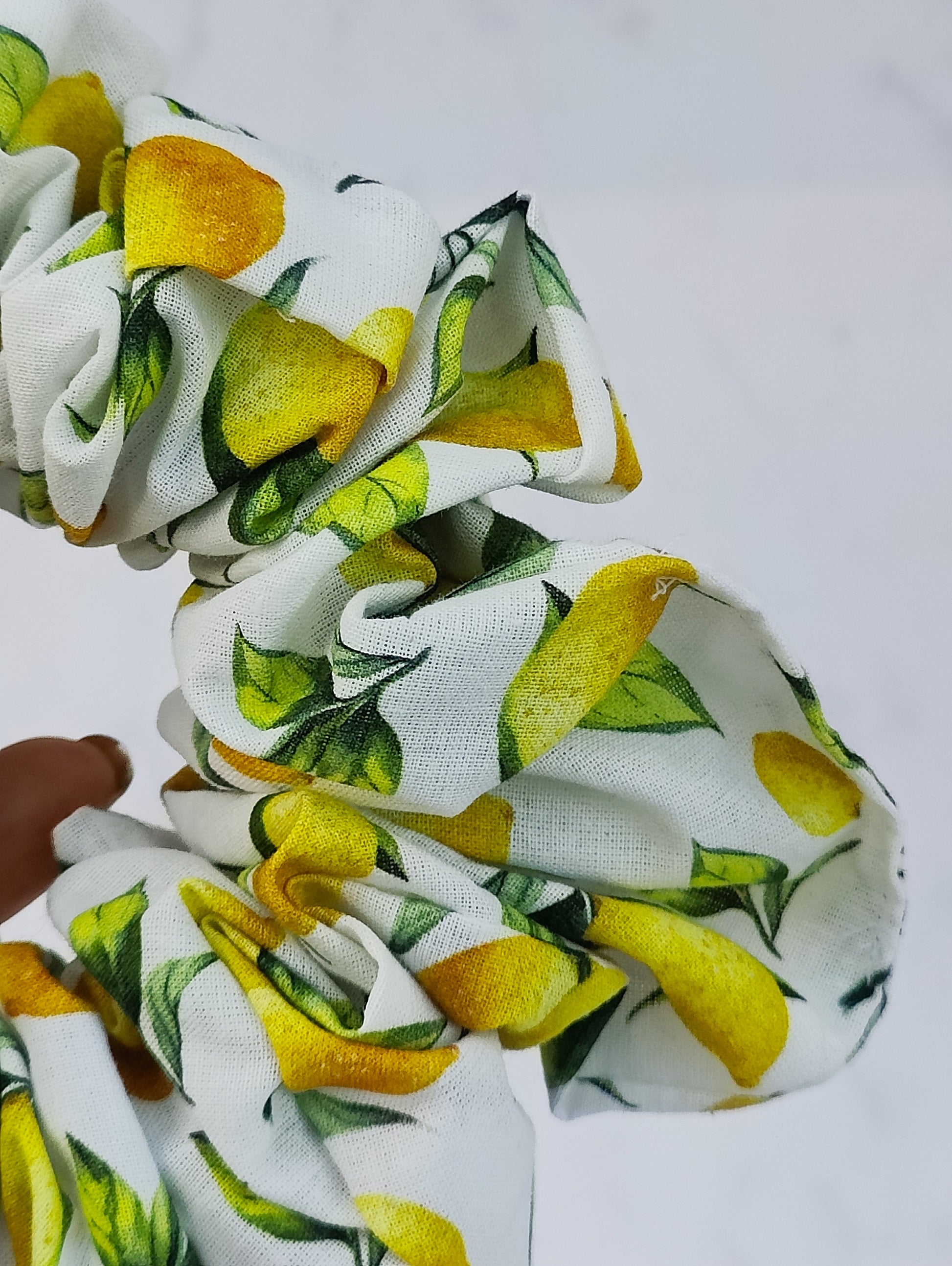 Handmade lemon print scrunchie with yellow lemons on white fabric hair tie